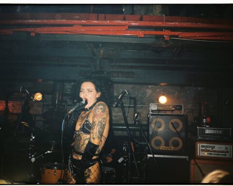 sid vicious - Tattooed female punk singer performing energetically on stage at a concert.