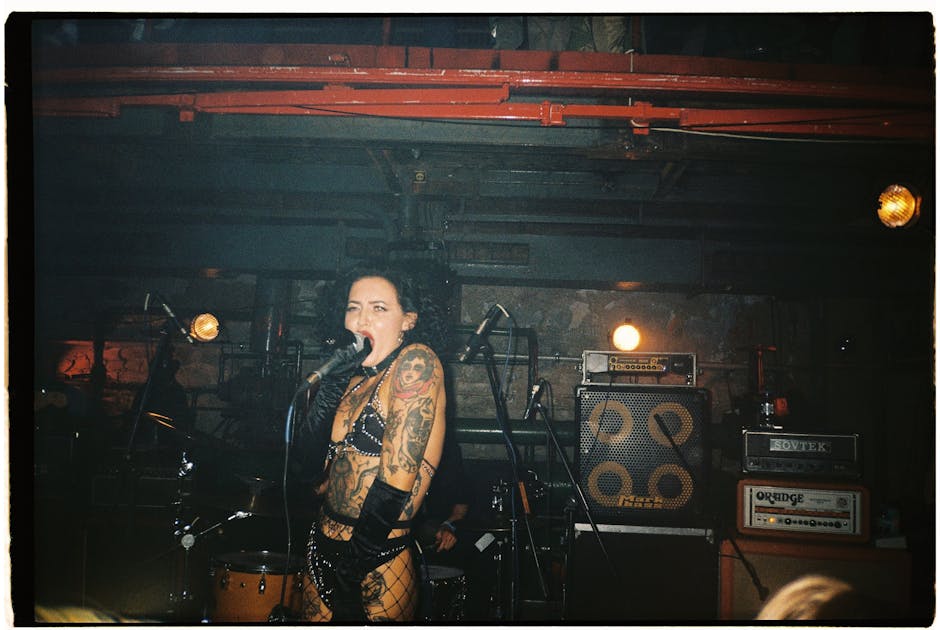 sid vicious - Tattooed female punk singer performing energetically on stage at a concert.